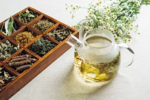 Una teiera con della tisana al suo interno vicino ad un porta tisane