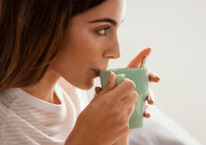 Una giovane ragazza che beve una tisana 