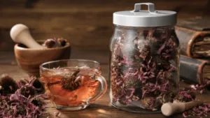 Composizione con una tisana, un recipiente con dei fiori officinali e altro